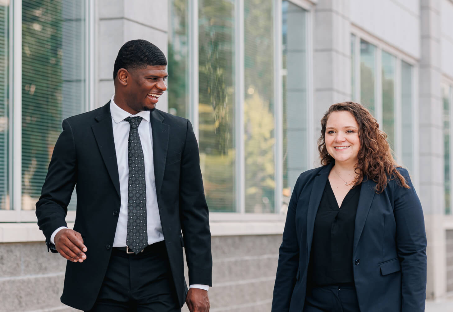 Two attorneys talking to each other while walking outside.